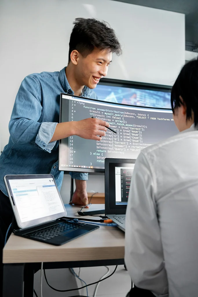 Web developers collaborating on backend code during AI plugin development by Ideal Web Design